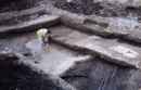 The ditch/pond showing the 12th century timbers, branches and brushwood. At the bottom right is the flint containing yellow pigment and the bottom right is part of the wooden bowl